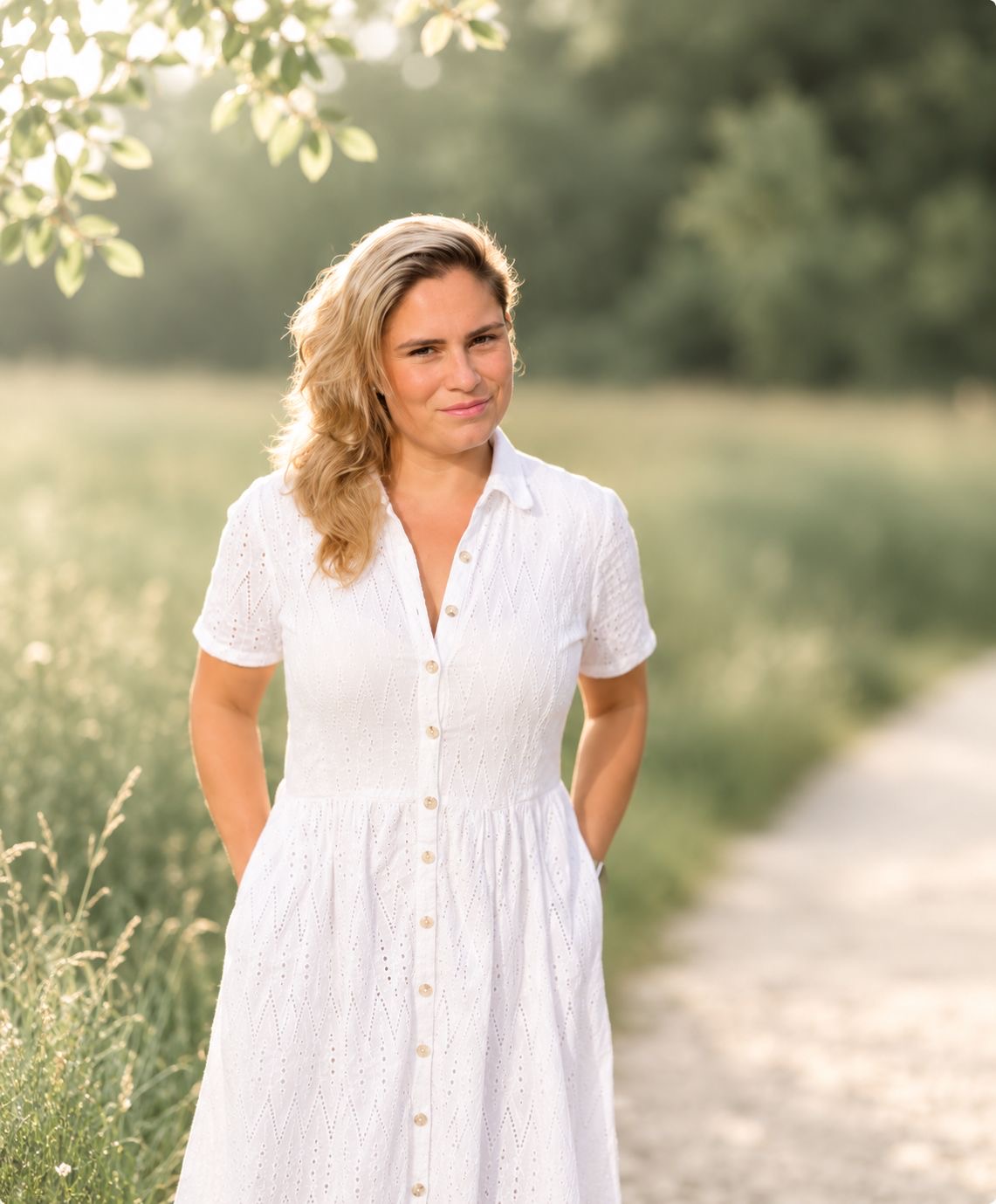 Portrait von Vanessa Melina, Psychosoziale Beraterin in Ausbildung, in einem weissen Kleid in der Natur