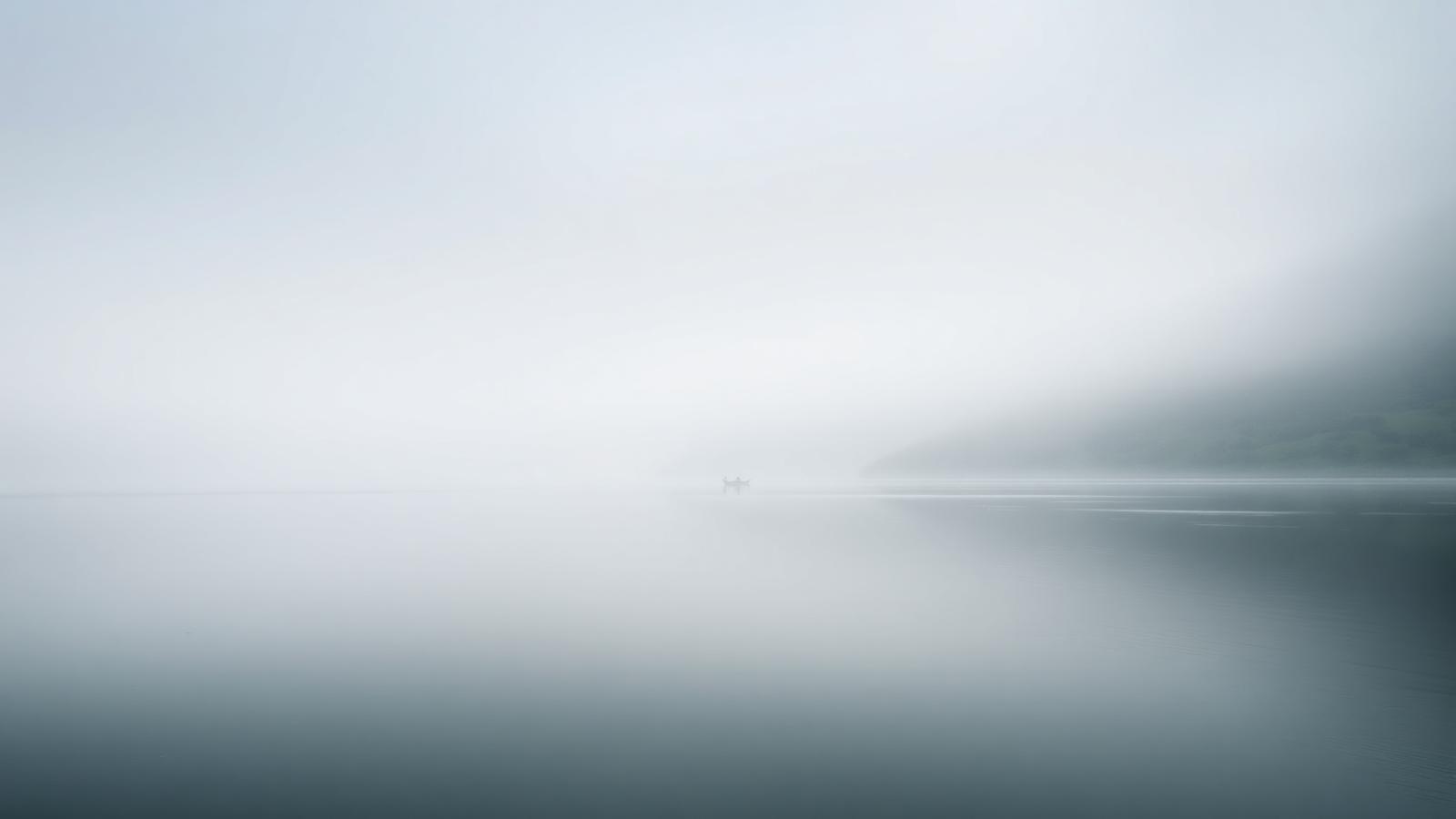 Ruhiger See im Morgennebel mit weichen Grautönen