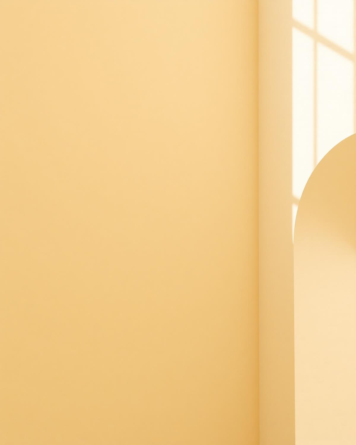 Warmes Licht und weiche Schattenlinien auf einer hellen Wand